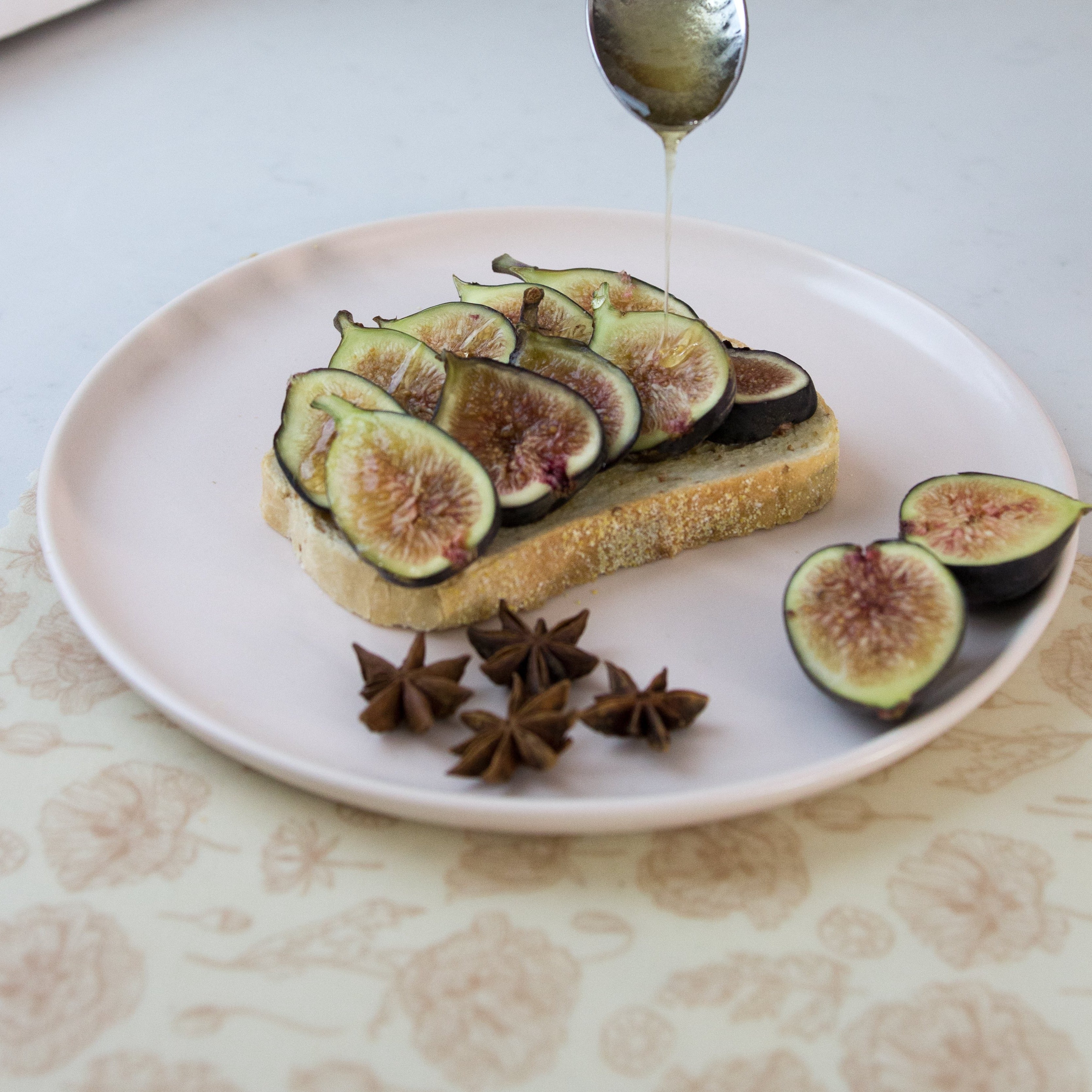 fig toast with a honey drizzle placed on top of a neutral toned floral beeswax wrap