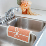 pink swedish dishcloth drying in the sink