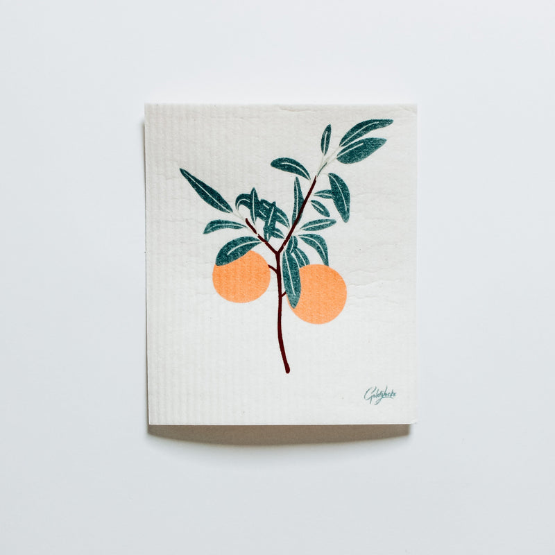 the clementine Swedish dishcloth features two bright oranges on a branch full of leaves
