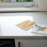 clementine and terrazzo Swedish dishcloths laying on kitchen counter