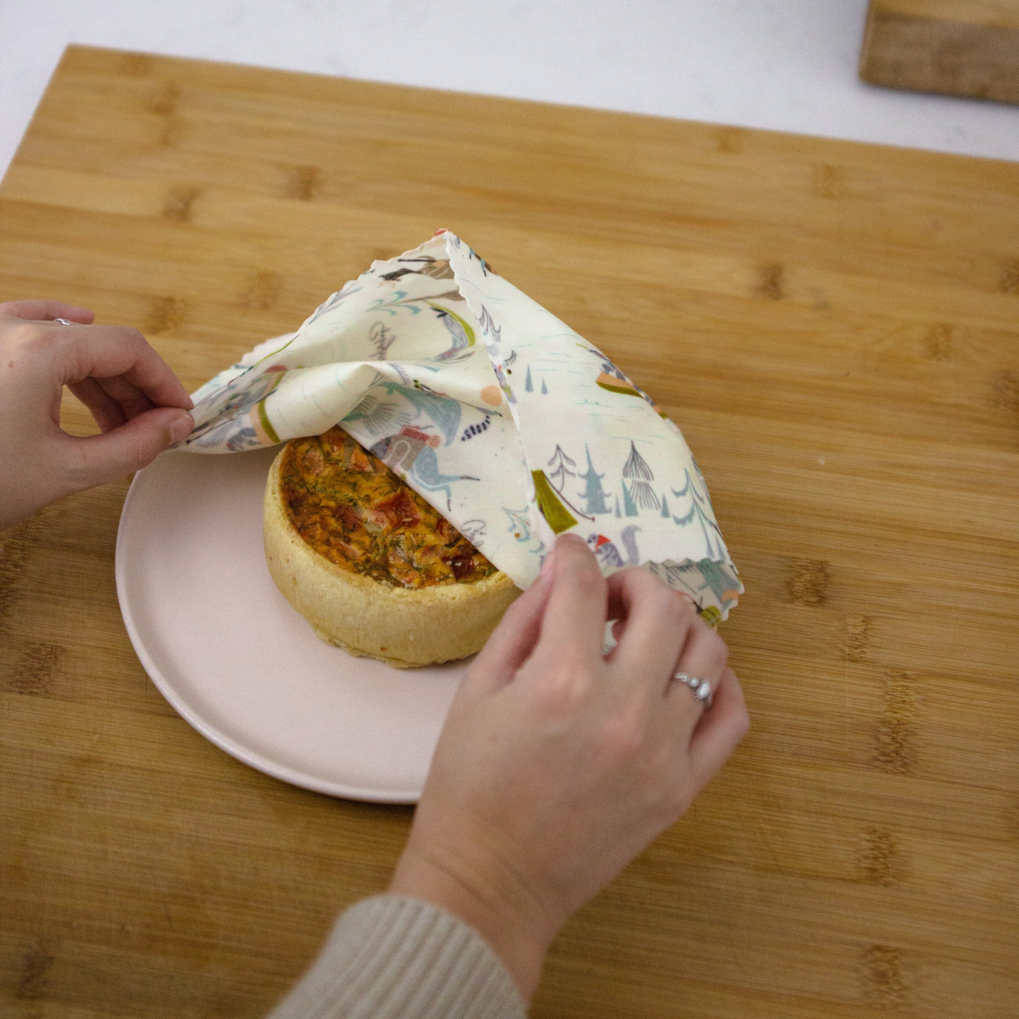 large furry friends beeswax wrap covering a mini quiche on a pink side plate